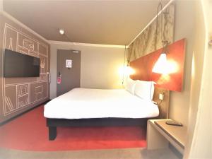 a bedroom with a large white bed and a tv at ibis Portsmouth in Portsmouth