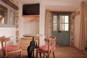 a room with two chairs and a table and a tv at - L'abri correzien - Cœur de cité médiévale in Donzenac