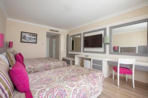 a bedroom with a bed and a desk and a tv at Orange County Belek in Belek
