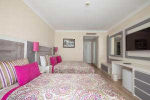 a hotel room with two beds and a television at Orange County Belek in Belek