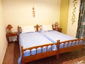 een slaapkamer met 2 bedden en 2 nachtkastjes bij Chez Effie in Kamena Vourla