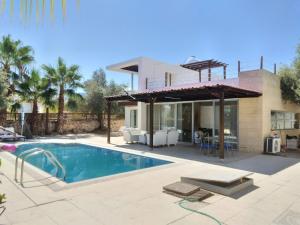 a villa with a swimming pool and a house at Aqua Royal Alexus Luxury Holiday Apartments Girne in Kyrenia