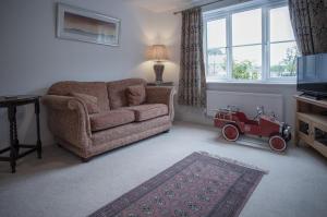 a living room with a couch and a red toy car at Maes Yr Odyn - 3 Bedroom Holiday Home - Narberth in Narberth