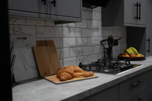 a kitchen counter with a tray of croissants and a stove at Ideal Lodgings in Accrington in Accrington