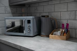 Un microondas sobre una encimera junto a un recipiente en Ideal Lodgings in Accrington, en Accrington