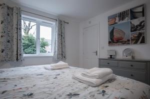 a bedroom with a bed with two white towels on it at Maes Yr Odyn - 3 Bedroom Holiday Home - Narberth in Narberth