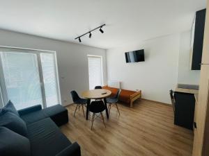 a living room with a table and a couch at Apartament Osiedle Okrzei in Kielce