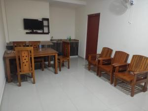 a dining room with a table and chairs and a tv at PMS Dhabi Residency in Kottakkal