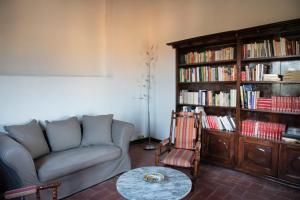 una sala de estar con sofá y una estantería llena de libros. en La galeria de dalt, en Rupià