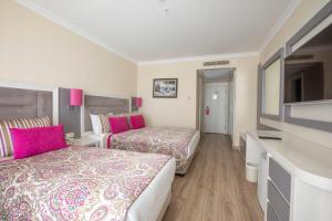 a hotel room with two beds and a television at Orange County Belek in Belek