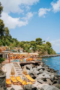 a group of yellow lounge chairs and the water at O' Vagnitiello - Parco Balneare Idroterapico - Camere - Ristorante in Ischia