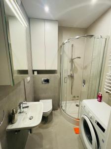 a bathroom with a shower and a sink and a toilet at Apartament Osiedle Okrzei in Kielce