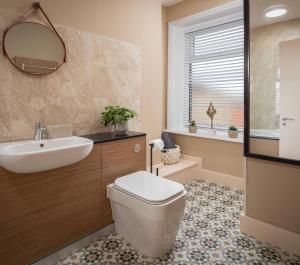 a bathroom with a toilet and a sink and a mirror at Coral Boutique Apartment 2 in Blackpool