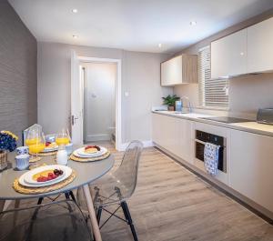 a kitchen with a table with plates of food on it at Coral Boutique Apartment 2 in Blackpool