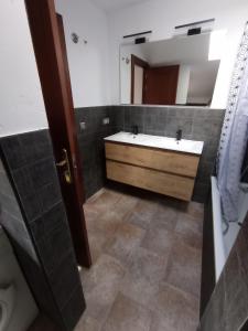 a bathroom with a sink and a large mirror at Hotel Cervaria in Cervera del Río Alhama