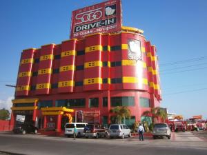 a red and yellow building with cars parked in front of it at Hotel Sogo Naga in Naga
