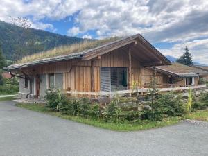 ein Haus mit einem Grasdach an der Seite in der Unterkunft Dobringers Chalet-Dorf Warös in Hermagor