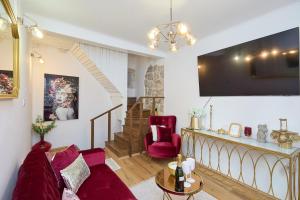 a living room with a couch and a tv at Old Town Casa Nevia- Deluxe Holiday Home in Dubrovnik with Stunning Views in Dubrovnik