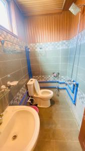 a bathroom with a toilet and a sink at Gems Palace Hotel Sost in Gircha