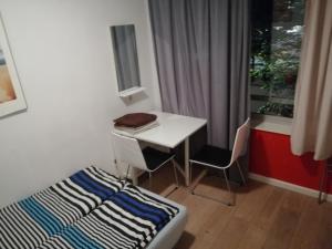 Habitación pequeña con escritorio, cama y ventana en All you need, a comfy place, en Ámsterdam