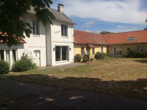 een wit huis met rode daken en een tuin bij La Canardière in Pendé