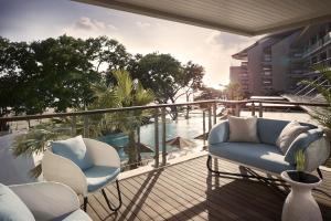 a balcony with chairs and a view of the water at Double - Six, Luxury Hotel - Seminyak in Seminyak