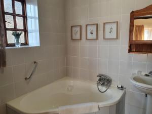 a bathroom with a bath tub and a sink at Lake Clarens Guest House in Clarens