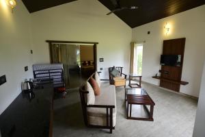 ein Wohnzimmer mit einem Sofa und einem Tisch in der Unterkunft vihangama Home Stay in Chāmundi