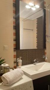 y baño con lavabo y espejo. en Bright Luxury Apt., en Volos
