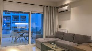 ein Wohnzimmer mit einem Sofa und einem Tisch in der Unterkunft Bright Luxury Apt. in Volos