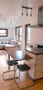 cocina y sala de estar con mesa y sofá en Auszeit auf 1000 m Höhe mit Familie & Hund, en Neukirch
