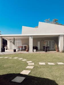 une grande maison blanche avec une cour en herbe dans l'établissement Coco Lodge, à Mthatha