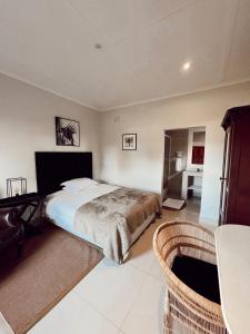 Un dormitorio con una cama y una mesa y sillas. en Coco Lodge, en Mthatha
