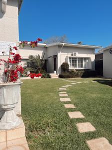 a house with a grass yard with a stone pathway at Coco Lodge in Mthatha +15 photos