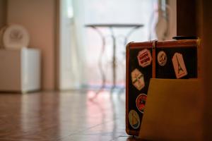 a suitcase with stickers on it sitting on a floor at B&B Il Melograno Taranto in Taranto
