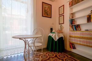 een tafel en stoel in een kamer met een raam bij B&B Il Melograno Taranto in Taranto