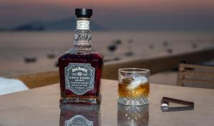 a bottle of whiskey sitting on a table next to a glass at Magic Klima II in Klima