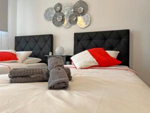 a bedroom with two beds and a clock on the wall at Albert's apartment Center 101 in Larnaca