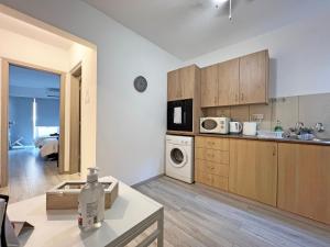 a kitchen with wooden cabinets and a room with a bed at Albert's apartment Center 101 in Larnaca