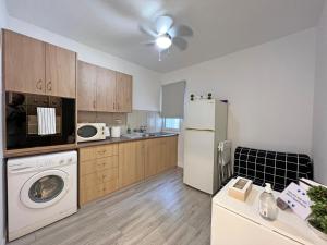 a kitchen with a washer and a white refrigerator at Albert's apartment Center 101 in Larnaca
