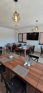 une salle à manger avec des tables et des chaises en bois dans l'établissement Bobocel Villa, à Sfântu Gheorghe