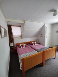 een slaapkamer met een bed met paarse lakens en een raam bij B&B Art Gallery 274 in Apeldoorn