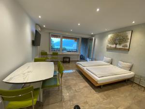 Zimmer mit einem Bett, einem Tisch und Stühlen in der Unterkunft Holiday On The Lake Lugano 6 in Bissone
