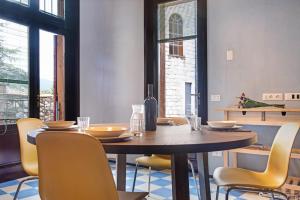 a dining room with a wooden table and yellow chairs at Cadepaia Lago Maggiore in Laveno-Mombello +11 photos