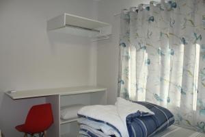 a small room with a desk and a red chair at Casatua in Pomerode