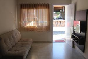 a living room with a couch and a sliding glass door at Casatua in Pomerode