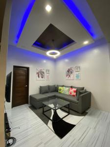 uma sala de estar com um sofá e uma mesa em Cozy Grace Place em Orani