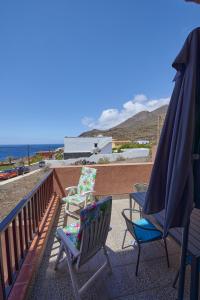 due sedie e un ombrellone su un balcone con vista sull'oceano di La Pardela - 2BR Sea Views Private Terrace - Wifi a Valverde