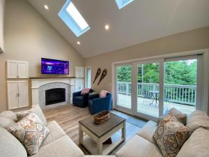 a living room with a couch and a fireplace at R7 Ski-in Ski-out Bretton Woods Townhome on 2-mile home trail Mt Washington views in Carroll