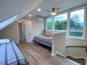 um quarto com uma cama e duas janelas em R7 Ski-in Ski-out Bretton Woods Townhome on 2-mile home trail Mt Washington views em Carroll